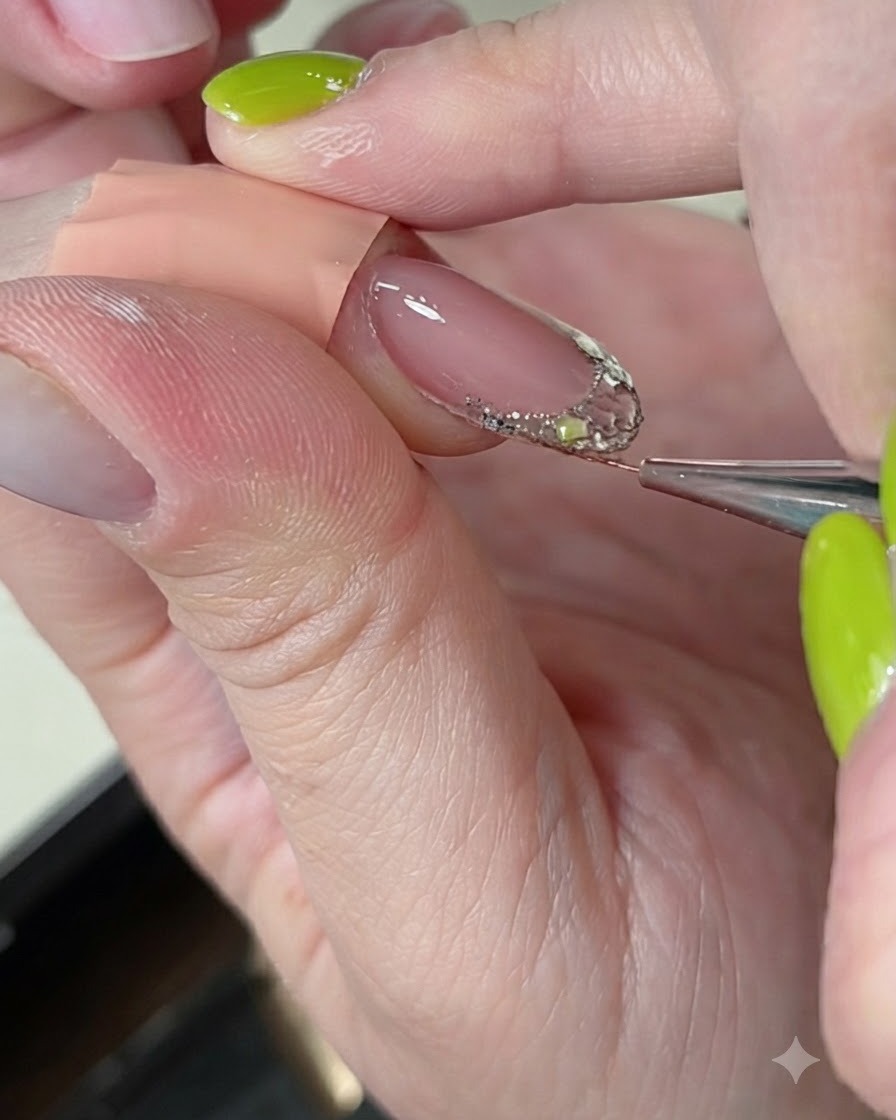Un pincel fino delineador alisando y refinando builder gel sobre una extensión de uña decorada.