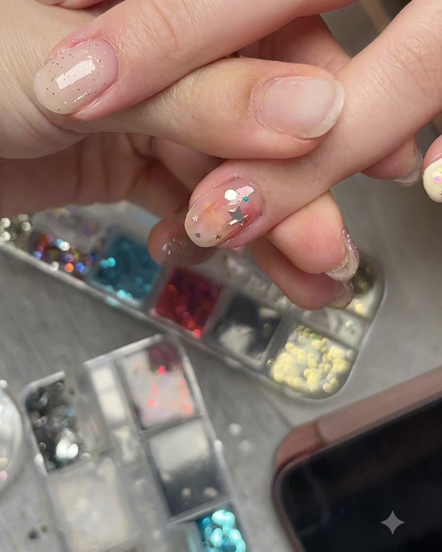 Nahaufnahme einer Hand, die ein vorgebogenes Stern-Glitzerstück auf einem Nagel aus einem Seitenwinkel betrachtet, um den bündigen Sitz zu zeigen.