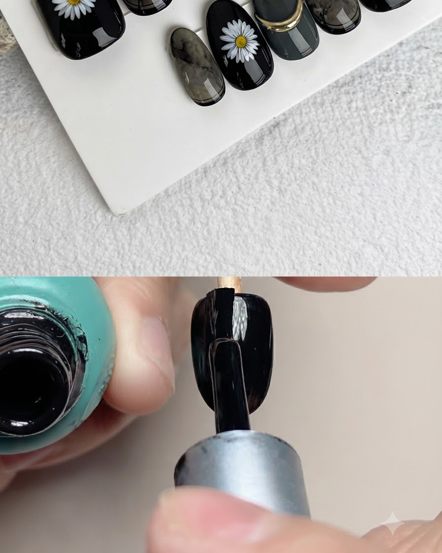 Primer plano de un pincel de uñas pintando pétalos blancos sobre la superficie de una uña artificial negra.