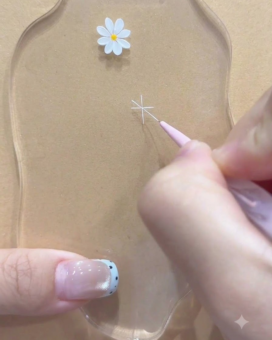 Un pincel delineador fino agregando líneas blancas diagonales adicionales para completar el contorno de la flor de margarita.