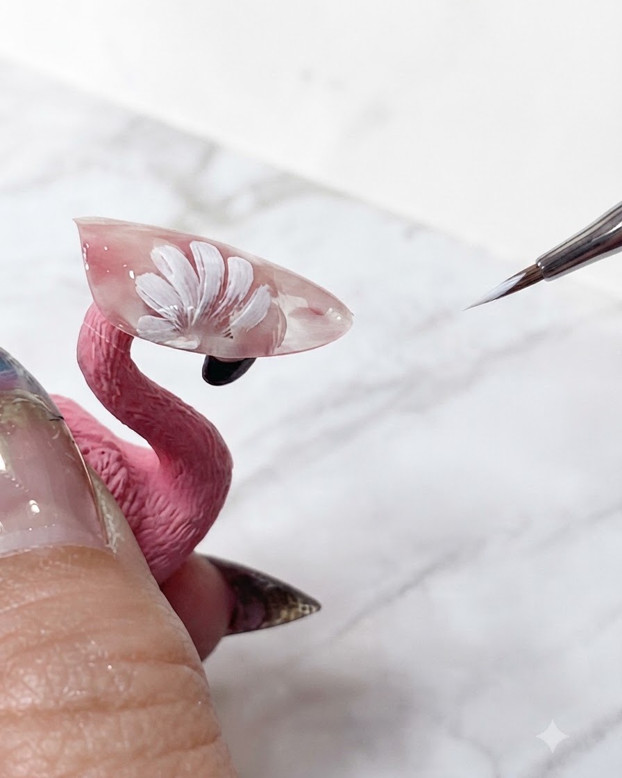 Un pincel de arte de uñas fino que retoca las puntas blancas nítidas de los pétalos de margaritas en capas en una extensión rosa translúcida.