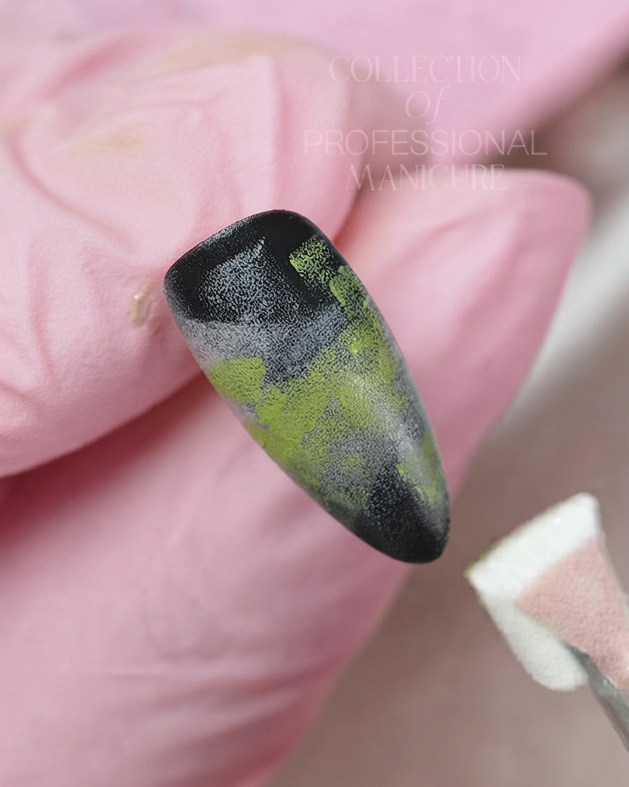 Un pincel delineador fino aplicando gel blanco para pintar una delicada flor de cinco pétalos sobre un fondo de uña degradado.
