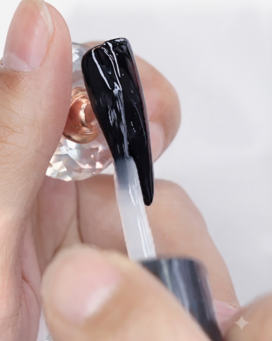 Un pincel aplicando una capa superior de gel mate transparente sobre una uña con esmalte en gel negro.
