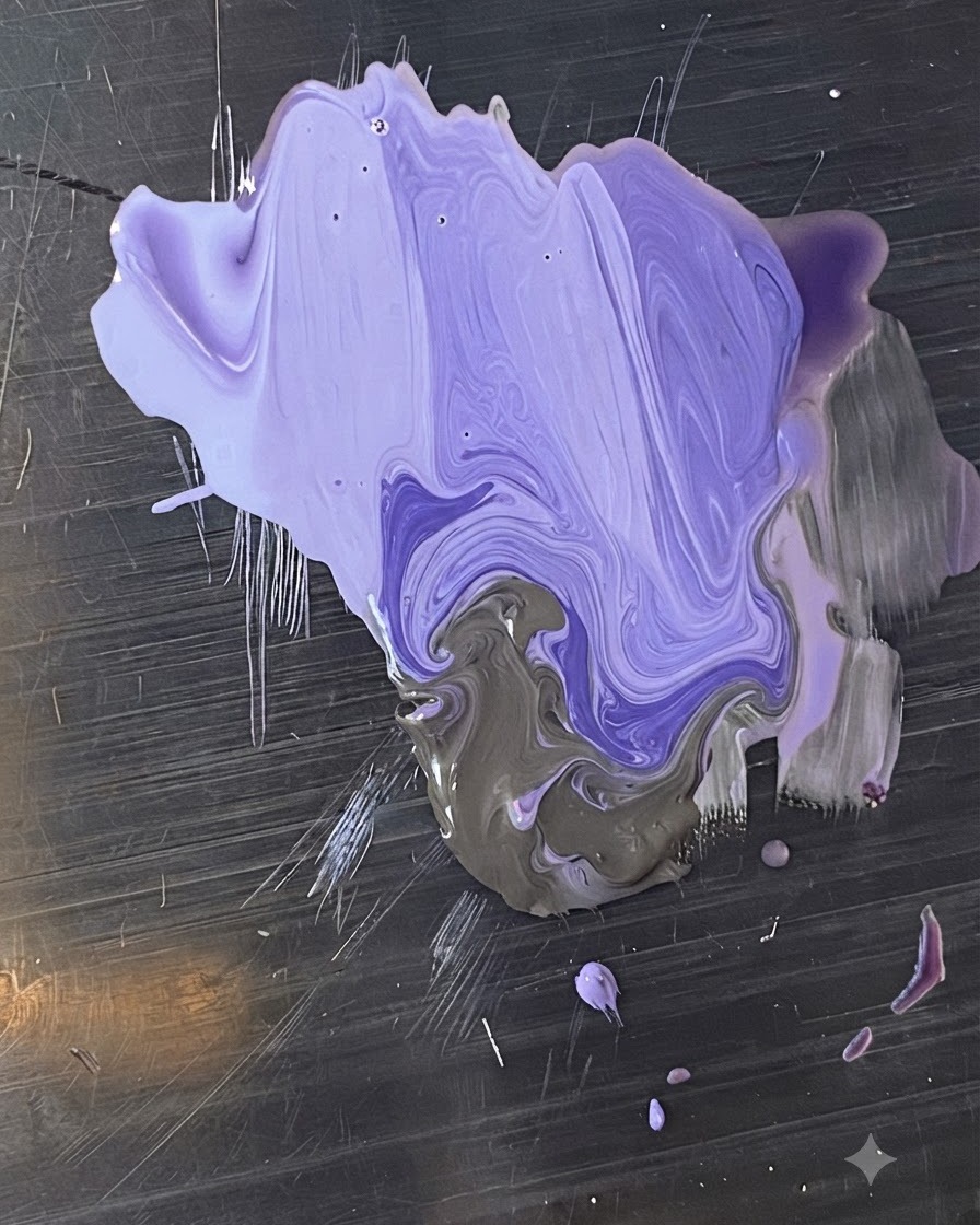 Una paleta metálica con tonos mezclados de esmalte en gel morado y gris siendo combinados por un pincel.