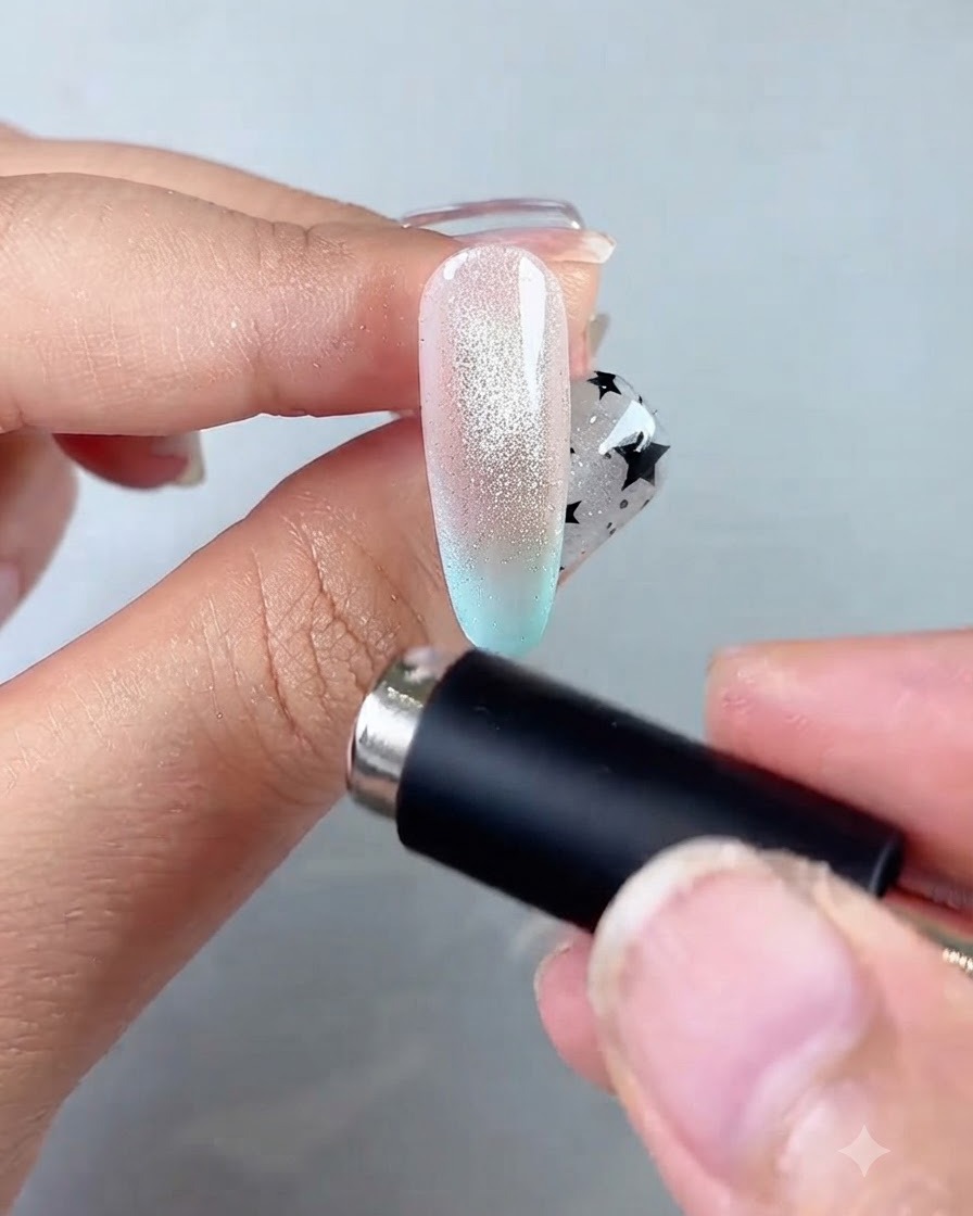 Una varita magnética rodeando el borde de la uña para formar un centro luminoso y concentrado de bola de cristal.