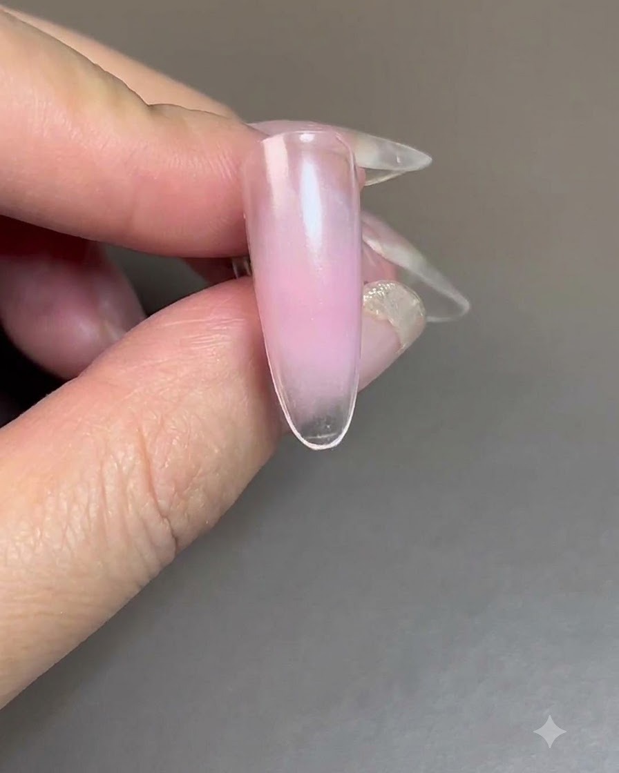 Una uña con gel de rubor curándose bajo una lámpara de uñas UV/LED.