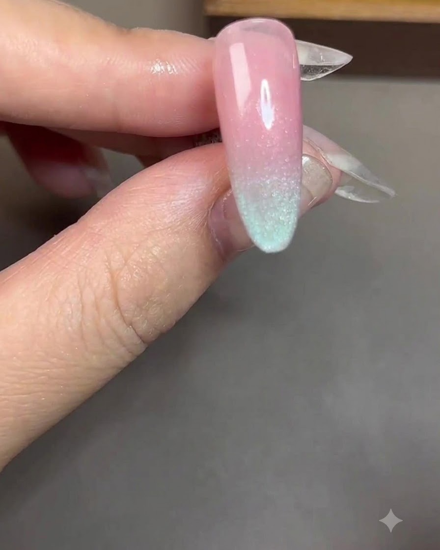 Un imán cilíndrico sostenido cerca y en paralelo a una uña recubierta con gel cat-eye azul.