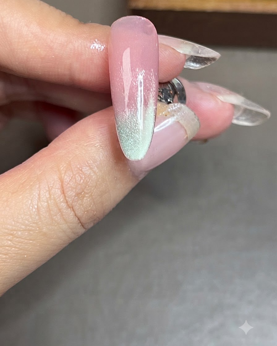 Una uña con una franja lateral cat-eye azul terminada después de ser curada bajo una lámpara.