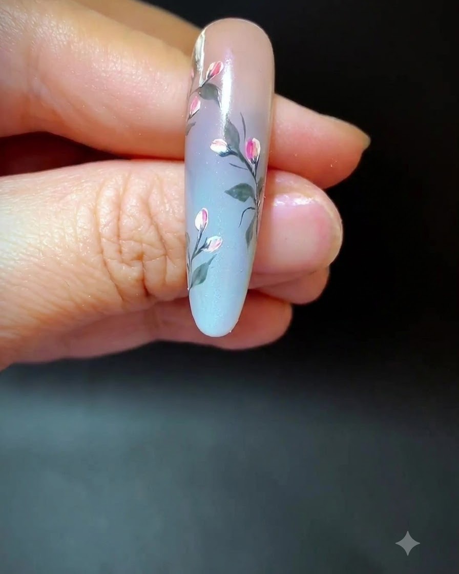 Una uña que muestra arte floral completo con líneas de acento largas y tenues añadidas a través del espacio degradado.