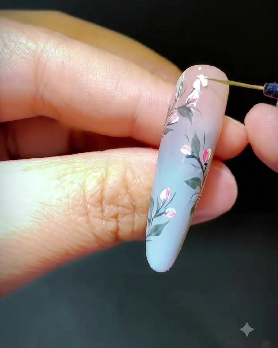 Una herramienta colocando fragmentos de concha triturada sobre gel húmedo para formar un diseño floral.