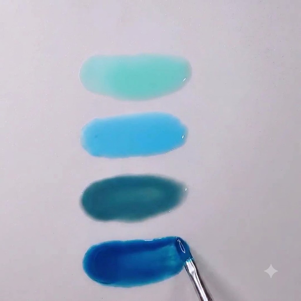 Un primer plano de un pincel de uñas suavizando los bordes de un charco de gel translúcido azul Morandi profundo.