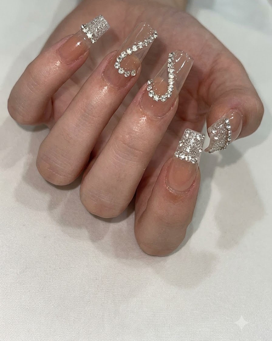 Una mano colocada bajo una lámpara de uñas UV/LED compacta para curar el diseño detallado de uñas.