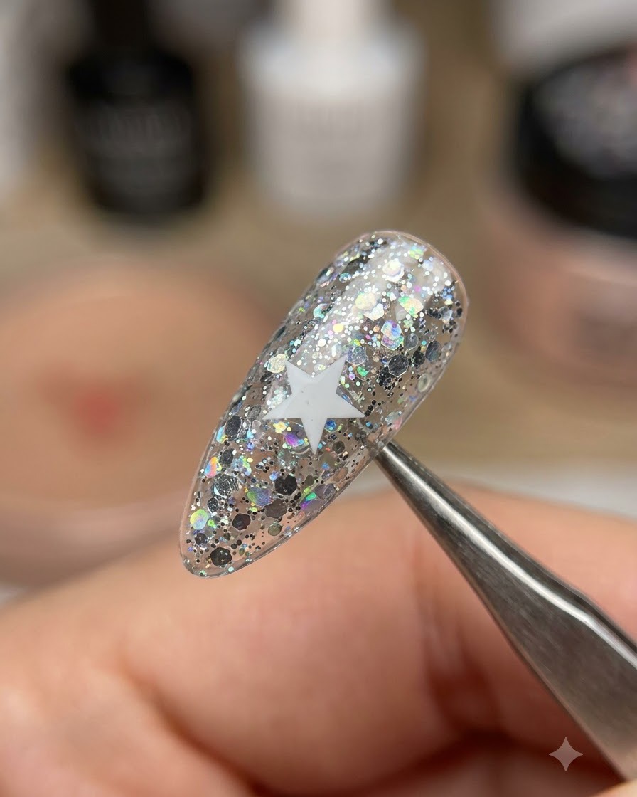 Un par de pinzas levantando una pegatina de estrella blanca de una uña con purpurina brillante.
