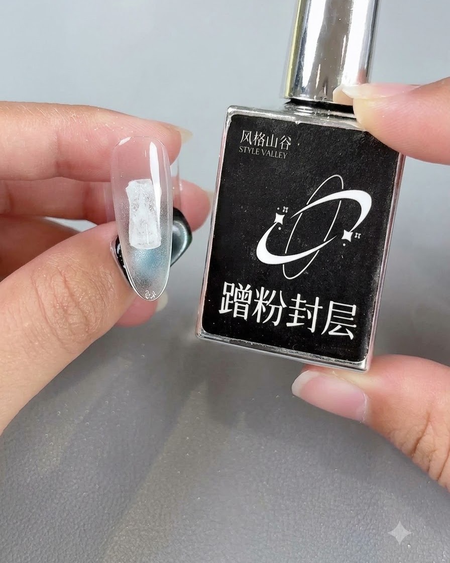 Mano sosteniendo un frasco negro junto a un tip de uña transparente con una capa de sellado curada.