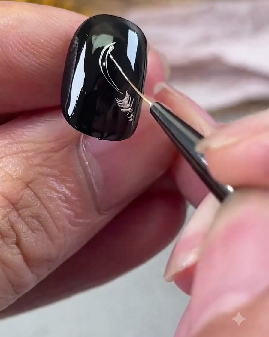 Pincel delineador dibujando líneas plateadas metálicas sobre una uña de gel negra.