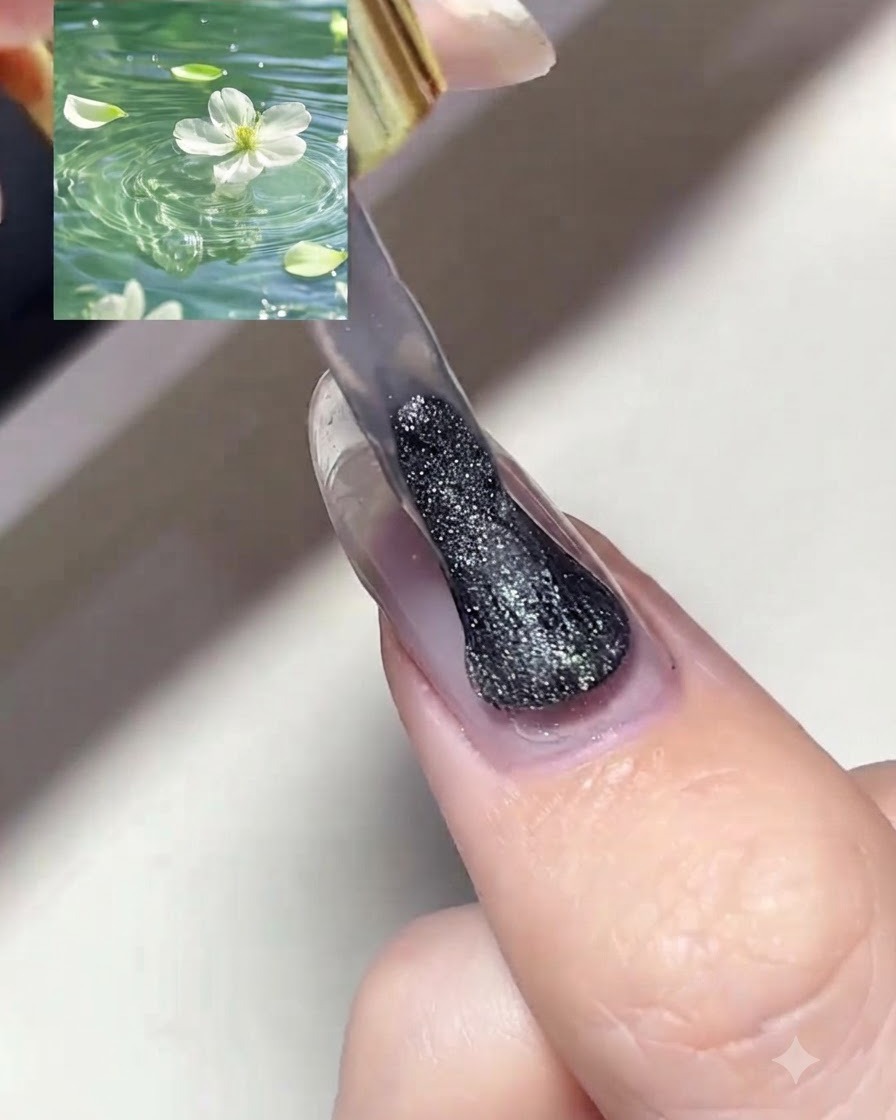 Un pincel aplicando una capa de esmalte en gel magnético plateado brillante con efecto ojo de gato sobre una uña preparada.