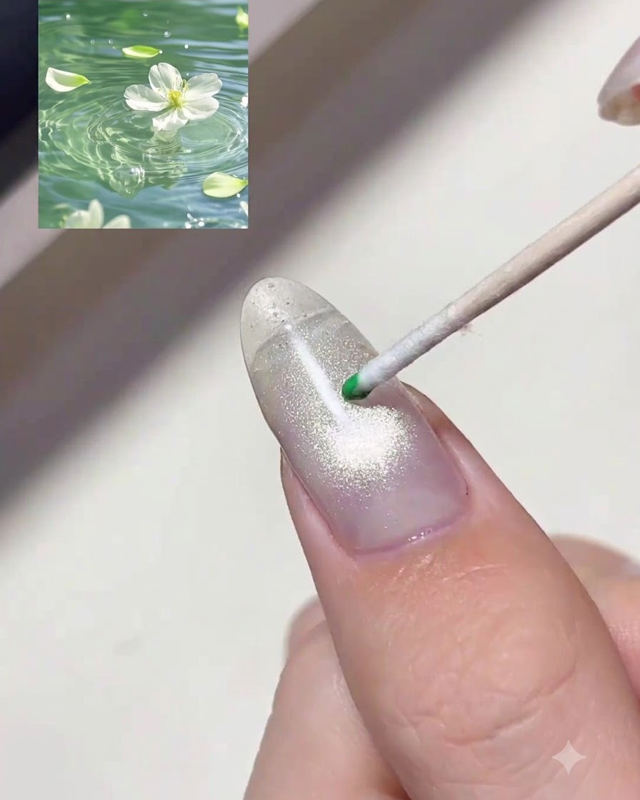 Un puntero de madera colocando una gota de gel tinte verde translúcido sobre una uña brillante.
