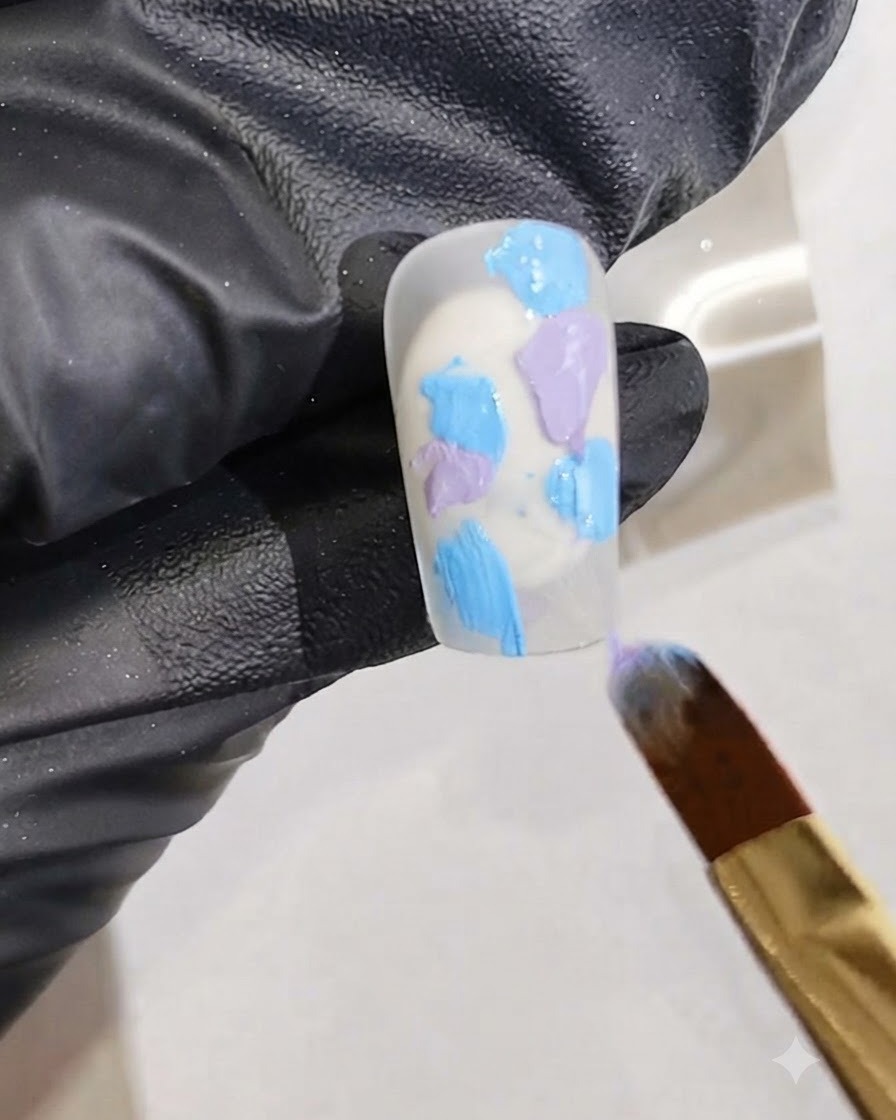 Un pincel fino añadiendo trazos de esmalte de gel rosa vibrante en la mezcla de gel húmedo sobre una uña.