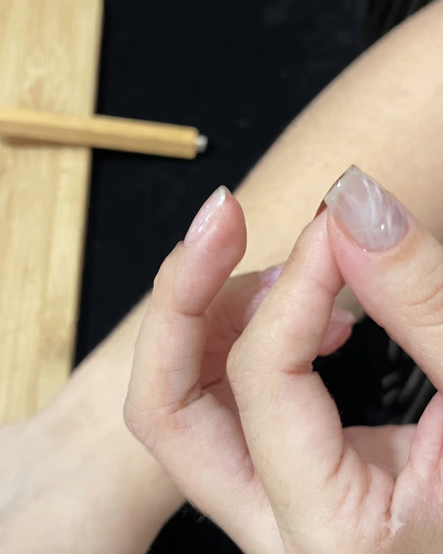 Una mano colocada bajo una lámpara de uñas UV o LED para curar la capa de gel texturizada.