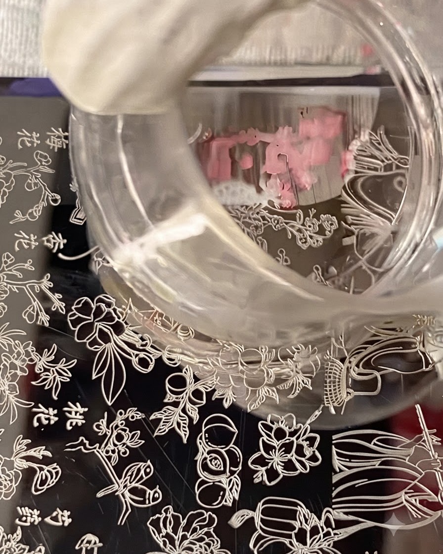 Un sello de silicona transparente flotando sobre una placa de estampación, capturando el diseño de nail art floral.