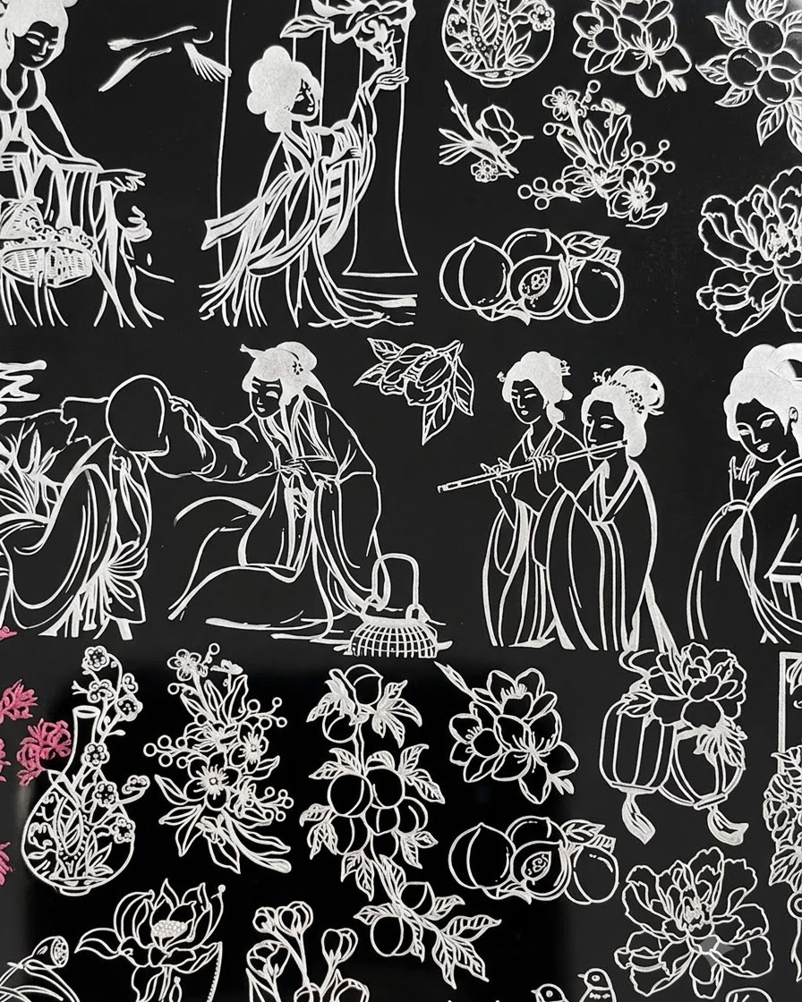 El diseño de una placa de stamping que muestra figuras femeninas tradicionales junto a arreglos florales, con acentos de color rosa visibles en el lado izquierdo.